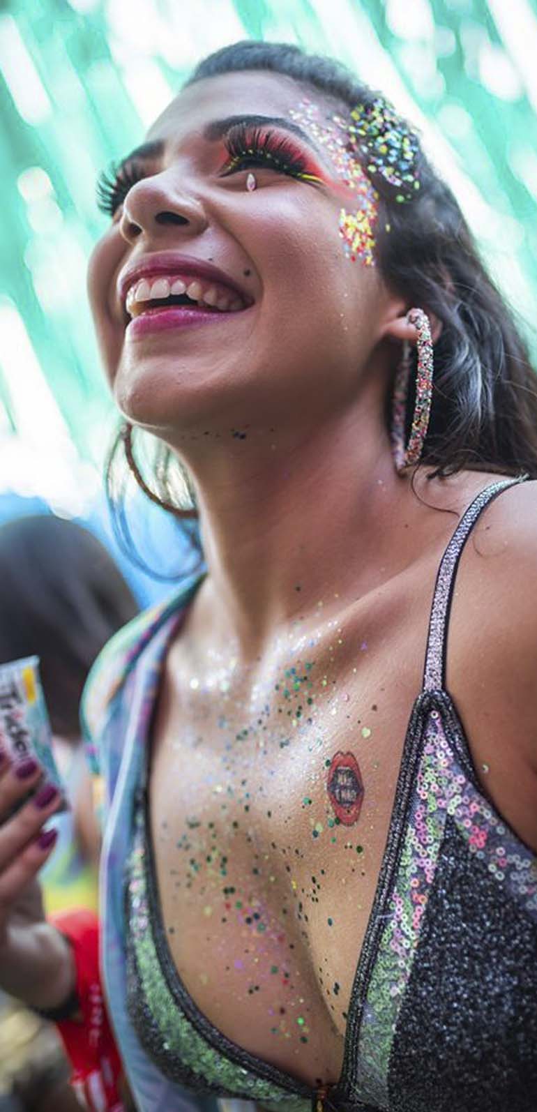 smiling woman get tattooed in event at São Paulo Carnaval