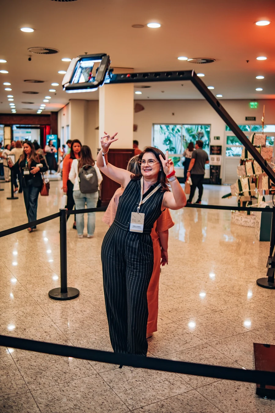 Guest posing beside the 180 Videobooth camera arm at a live event