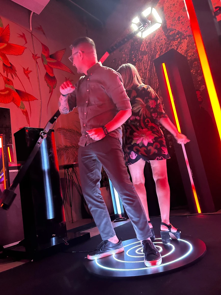 Guests standing on an illuminated 180 Videobooth platform in a red environment