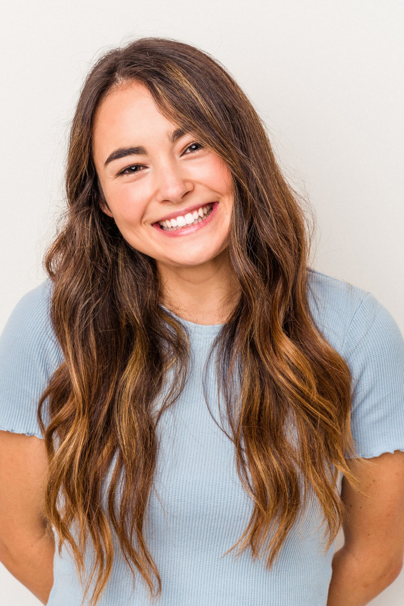 mulher brancav Happy cheerful dark skinned girl smiles gently, satisfied with result of exam she passed, dressed in casual beige sweater, isolated over white background with free space on right side for promotion